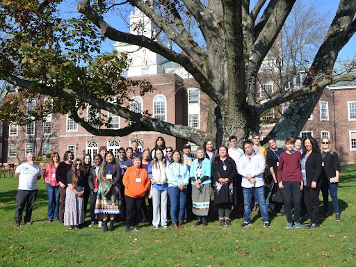 Attendees of the 2023 Munsee Language & History Symposium gather under a grandfather tree after the closing Talking Circle on Lu