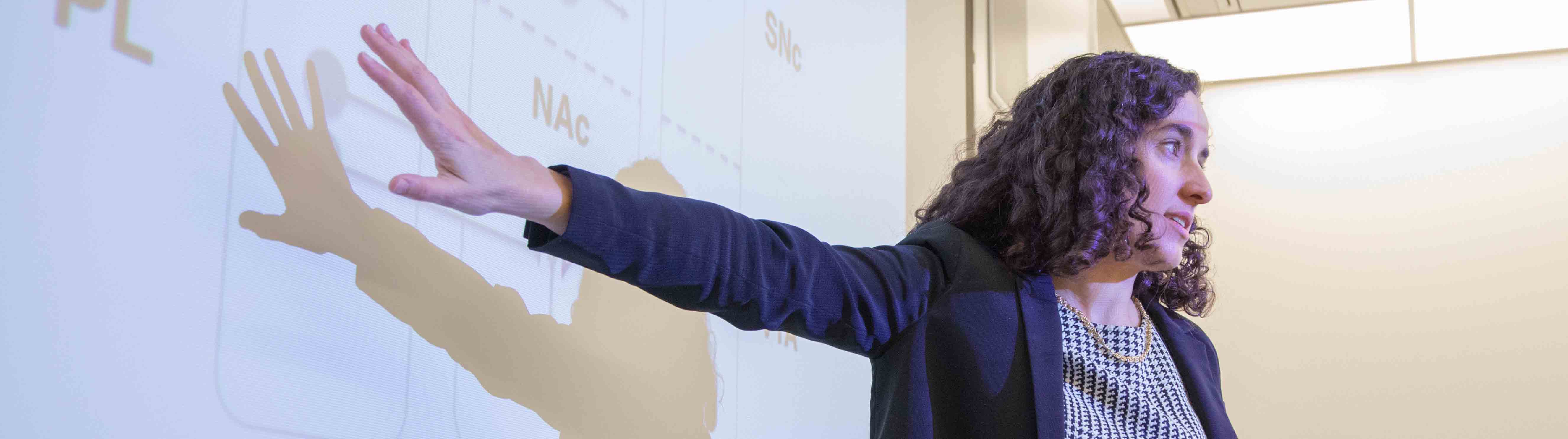 Professor Ilana B. Witten teaching a neuroscience course and pointing at the whiteboard