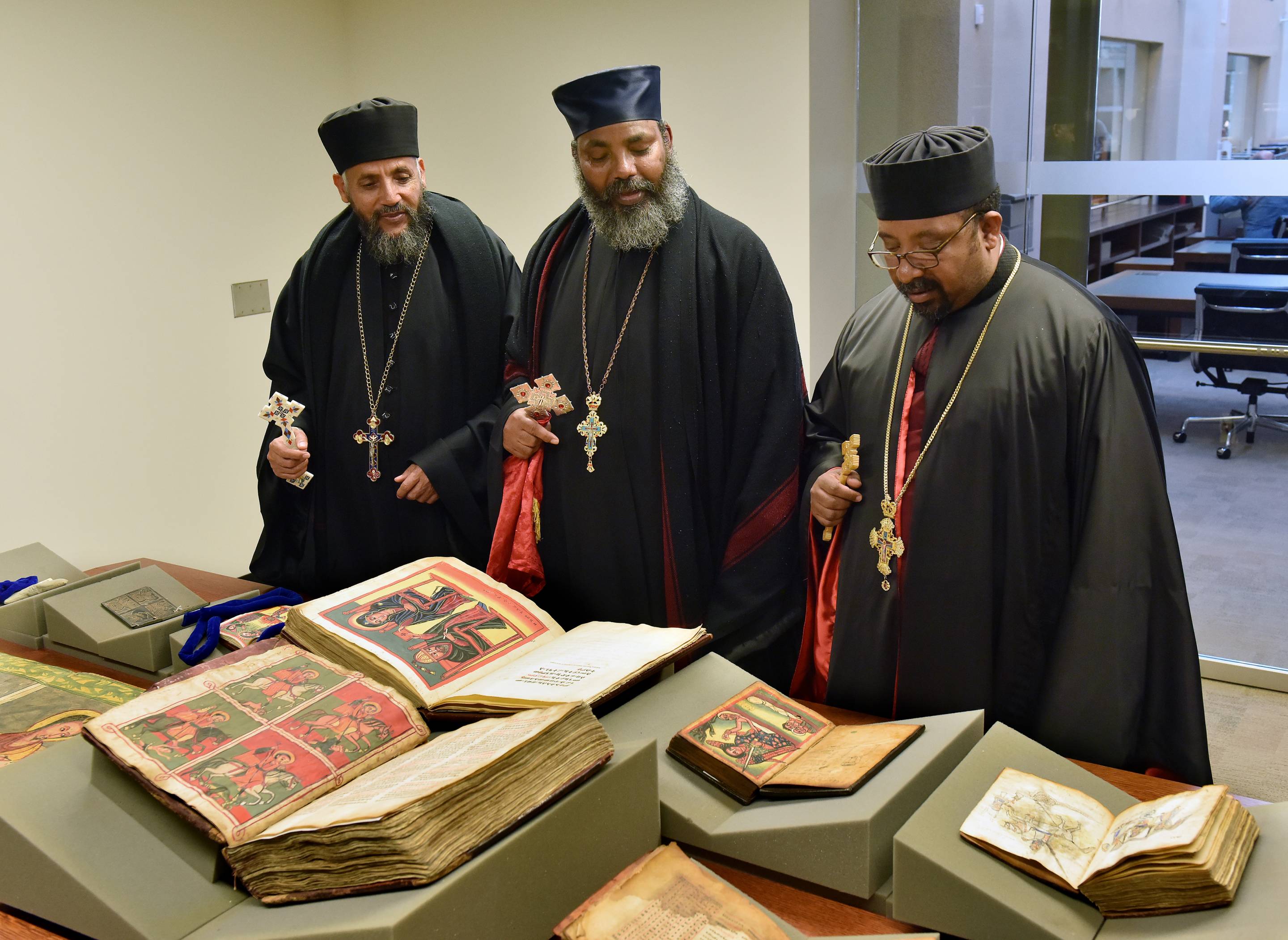 Priests view the selection of manuscripts on display.