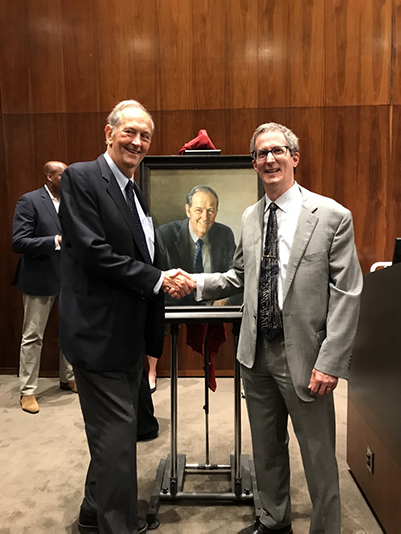 Bill Bradley '65 shakes hands with University Archivist Dan Linke in front of his new portrait at Princeton University. 