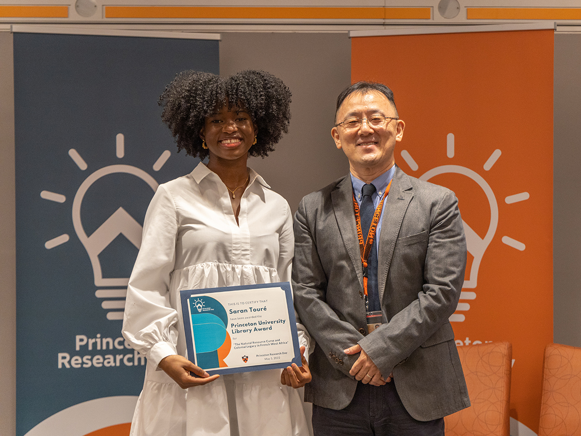 Saran Touré holds her Princeton Research Day award with Assistant University Librarian Peter Bae