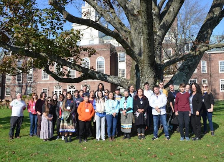 Attendees of the 2023 Munsee Language & History Symposium gather under a grandfather tree after the closing Talking Circle on Lu