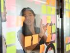 researchers working with sticky notes on glass wall